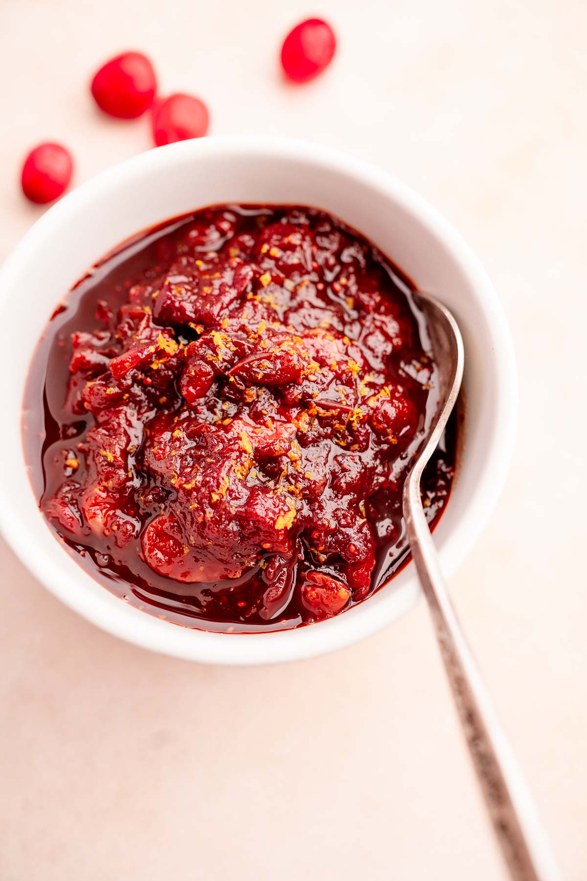 Slow cooker cranberry sauce in a bowl with a spoon.
