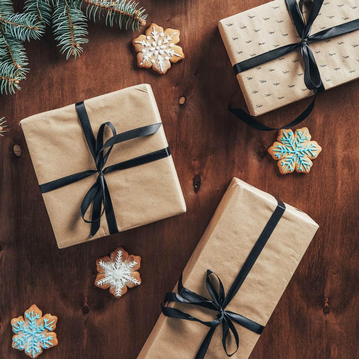 Christmas presents wrapped in brown paper on a wooden table.