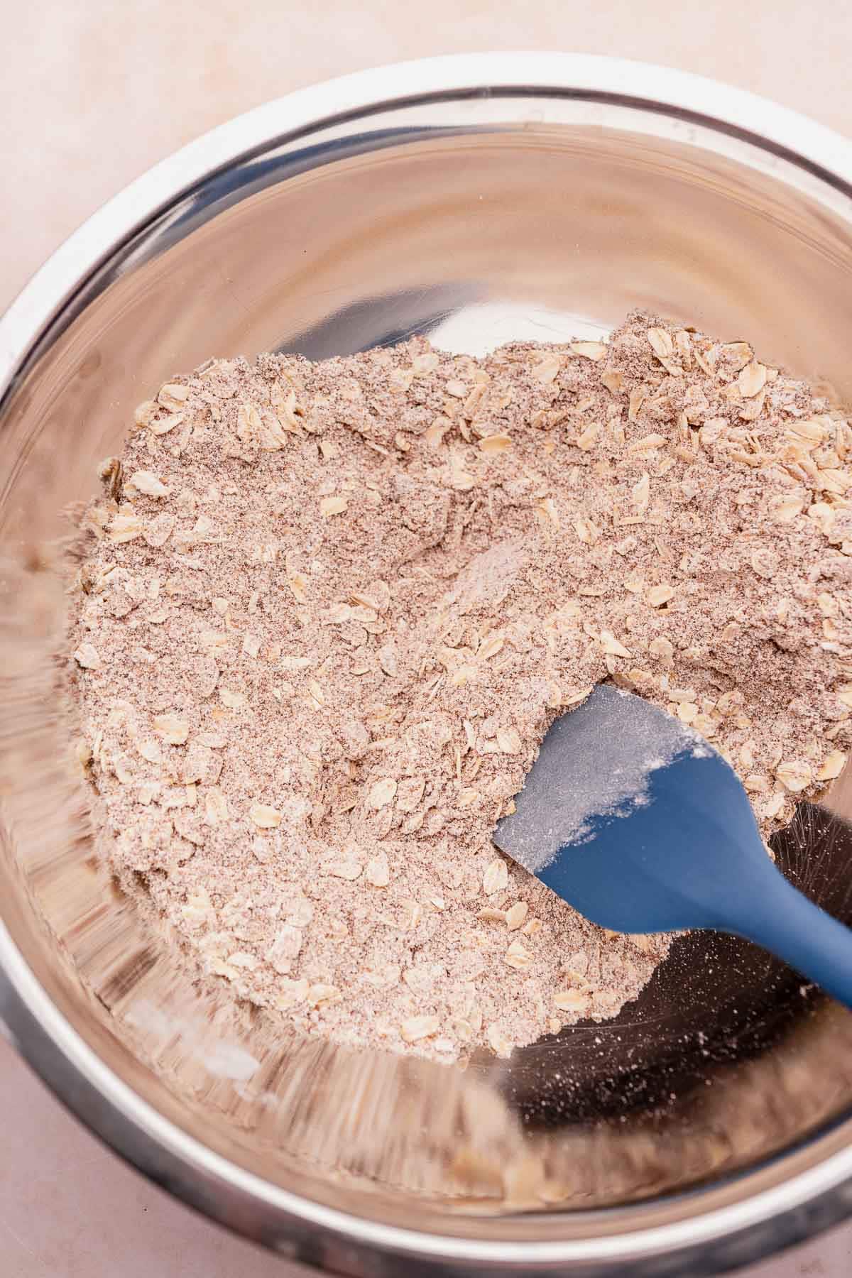 Gluten-free oats in a bowl with a blue spatula.