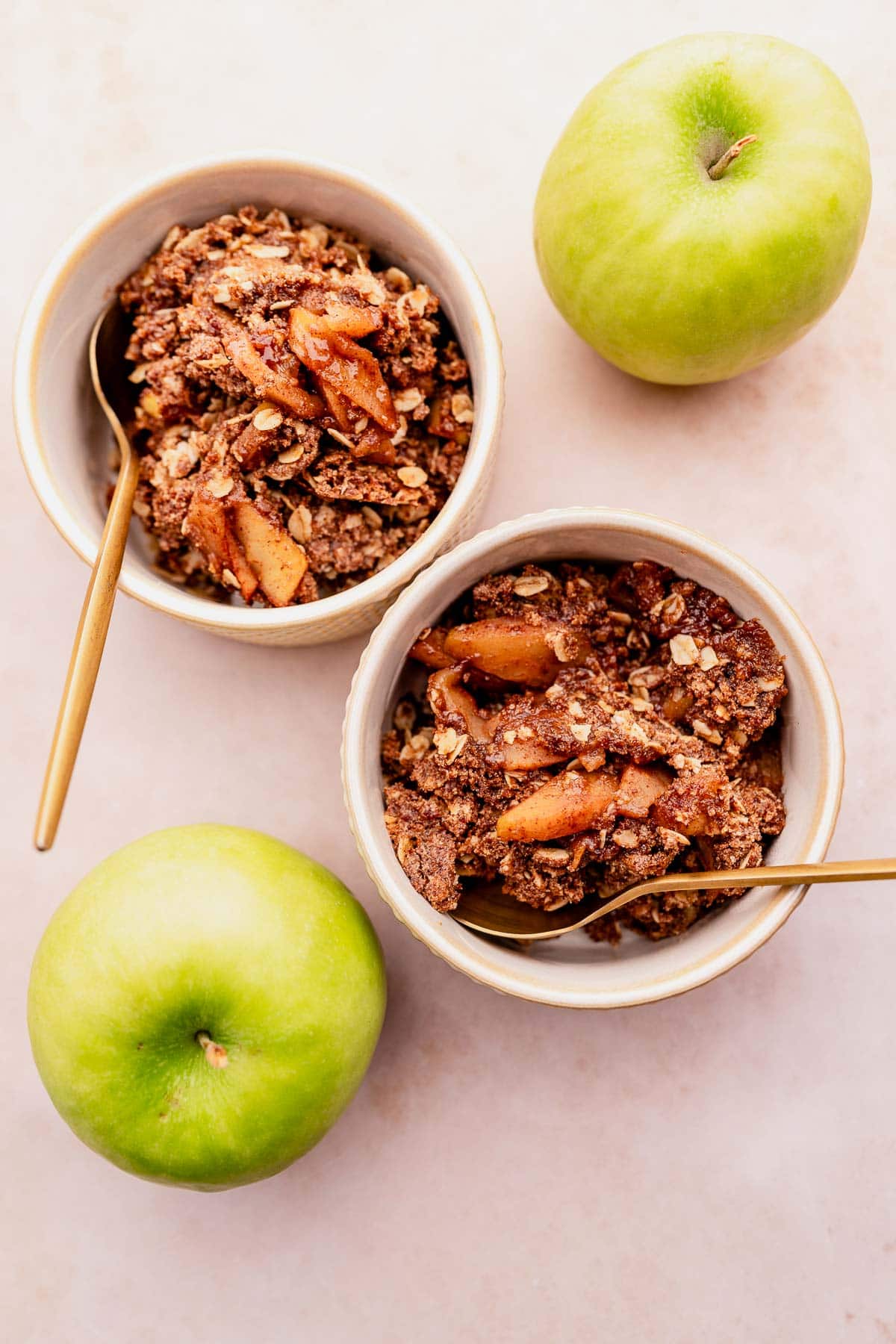 Two bowls of gluten-free apple crisp with apples and granola topping.