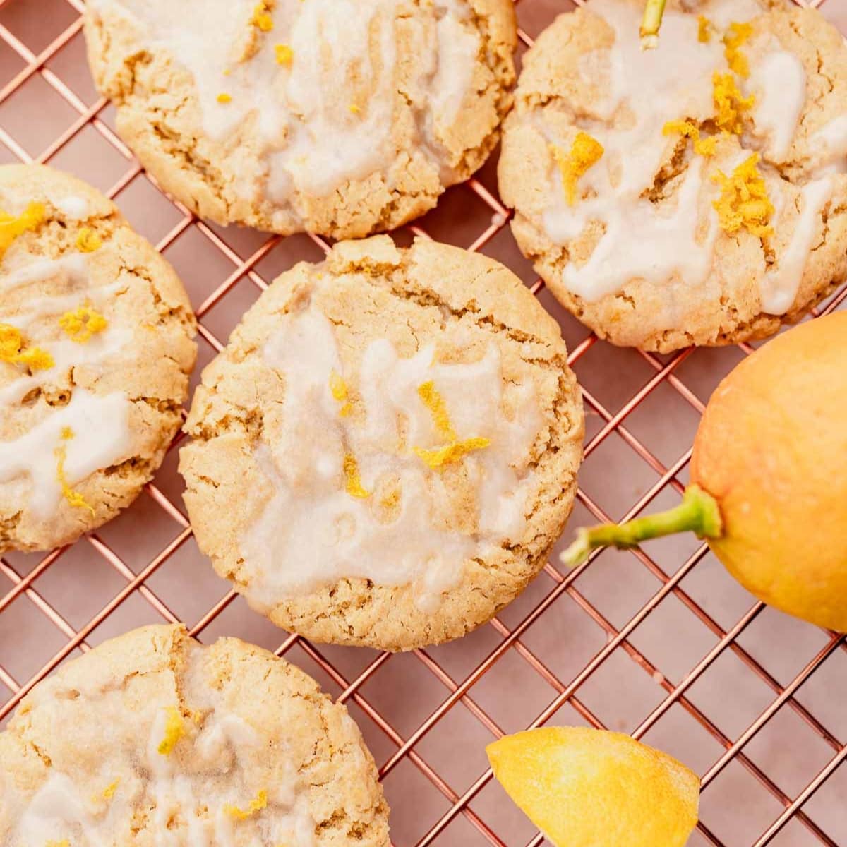 Gluten-free lemon cookies with icing on a cooling rack.