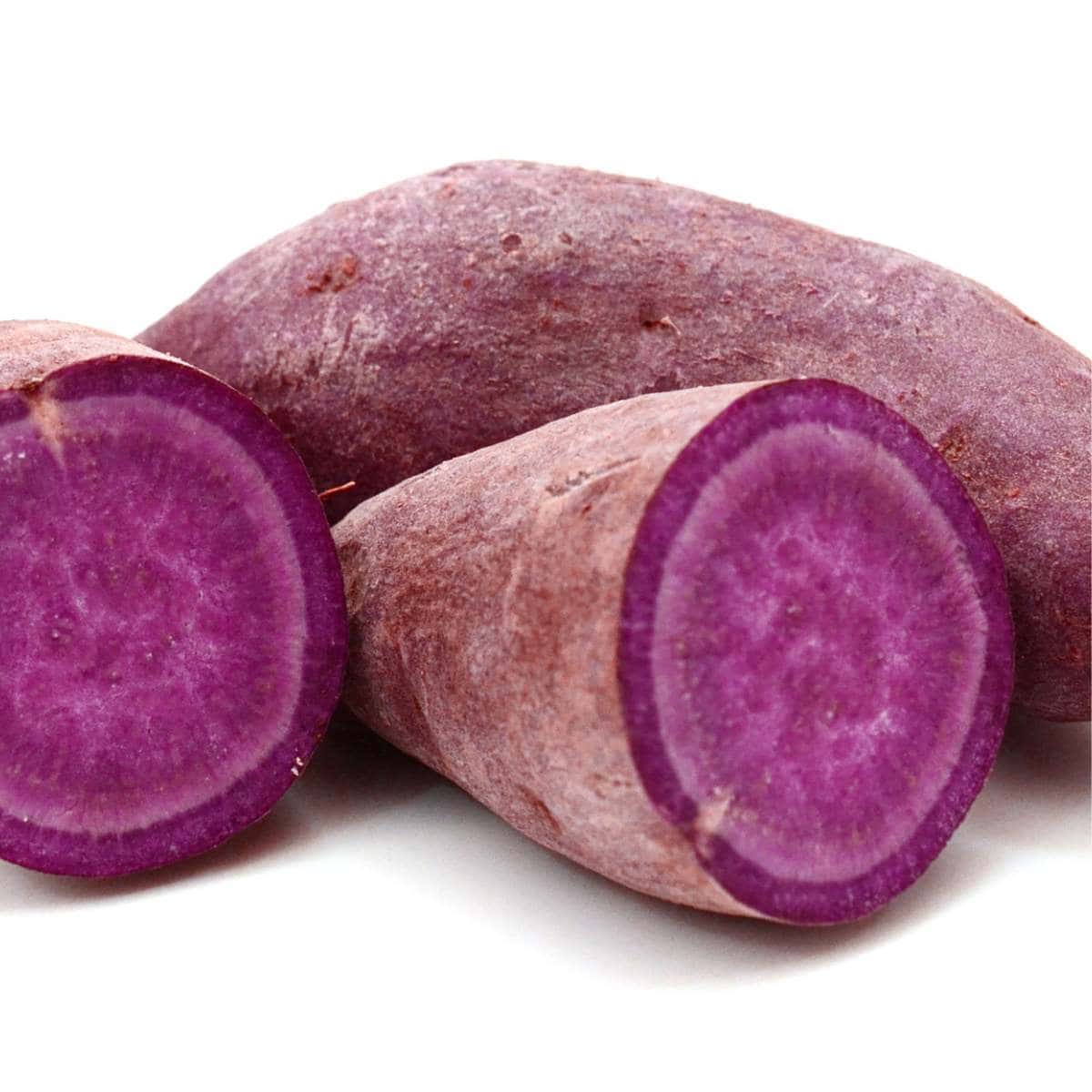         Three purple sweet potatoes on a white background.