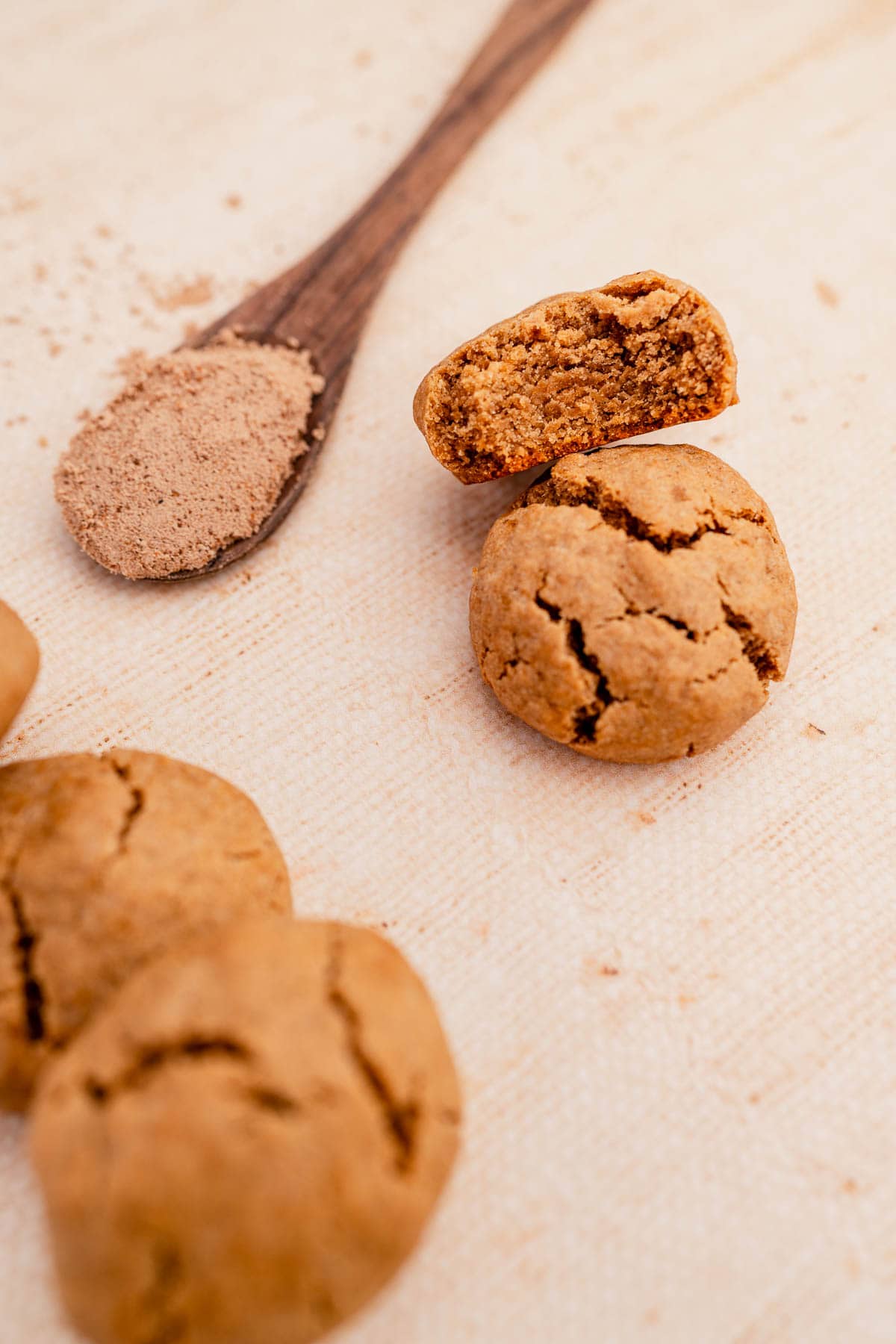 A wooden spoon next to some ginger chai cookies.