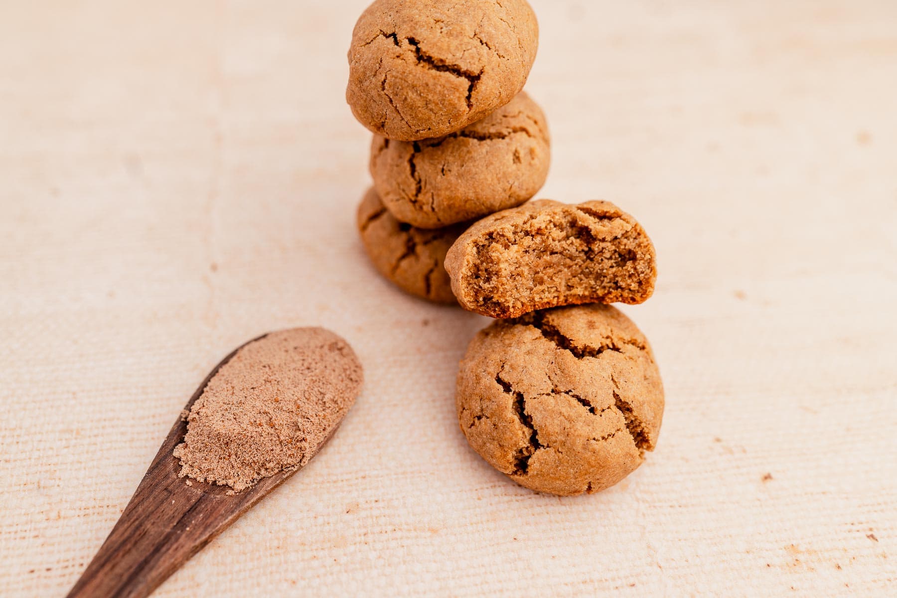 A stack of ginger chai cookies with a wooden spoon.