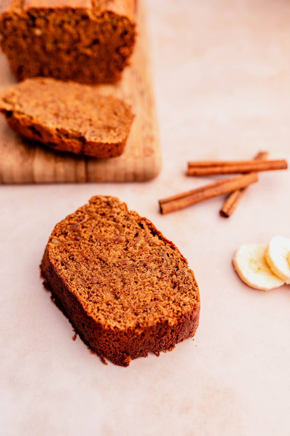 A slice of banana bread made with oat flour on a cutting board.