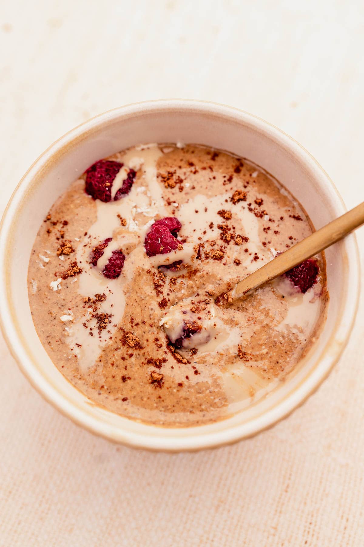 A bowl of oatmeal with blended raspberries.