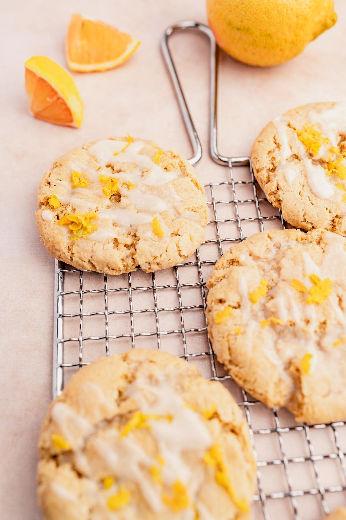 Gluten-free lemon cookies on a cooling rack with orange slices.