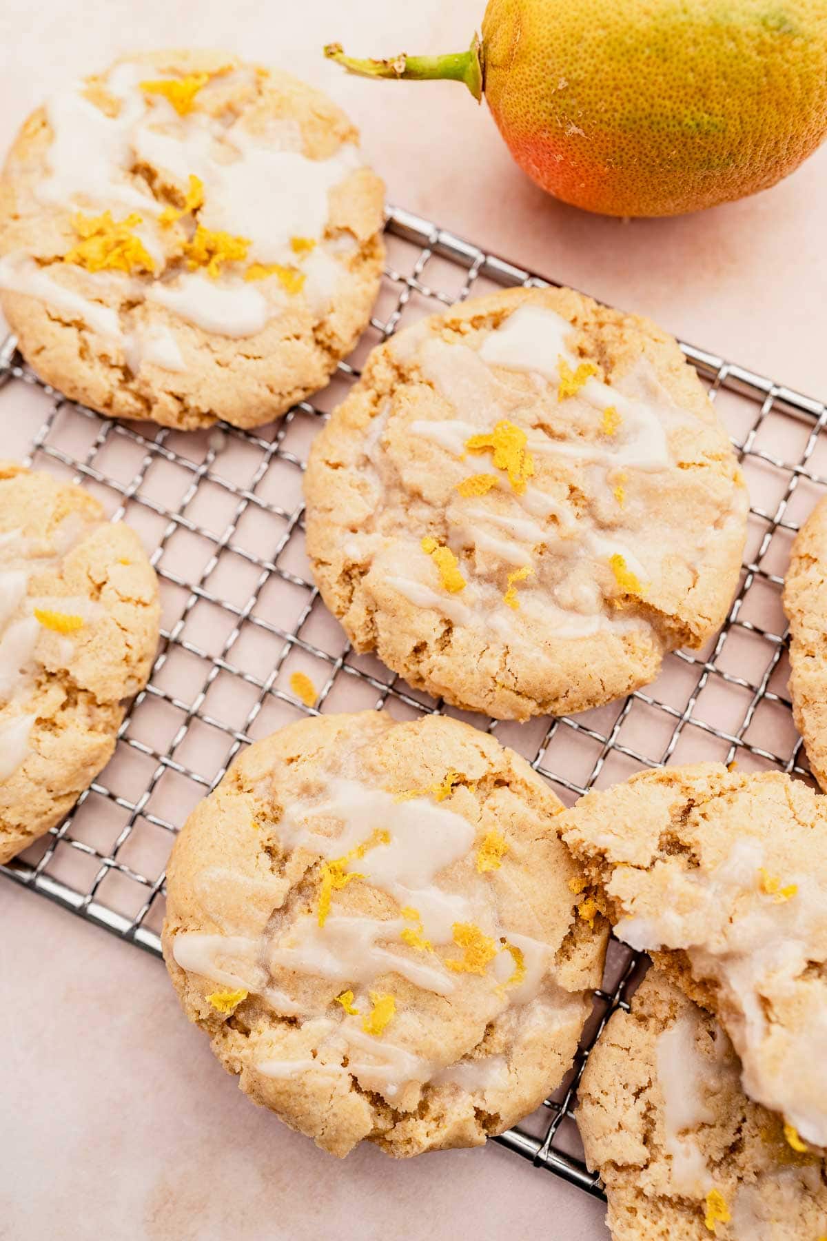 Gluten-free lemon mango cookies with icing on a cooling rack.