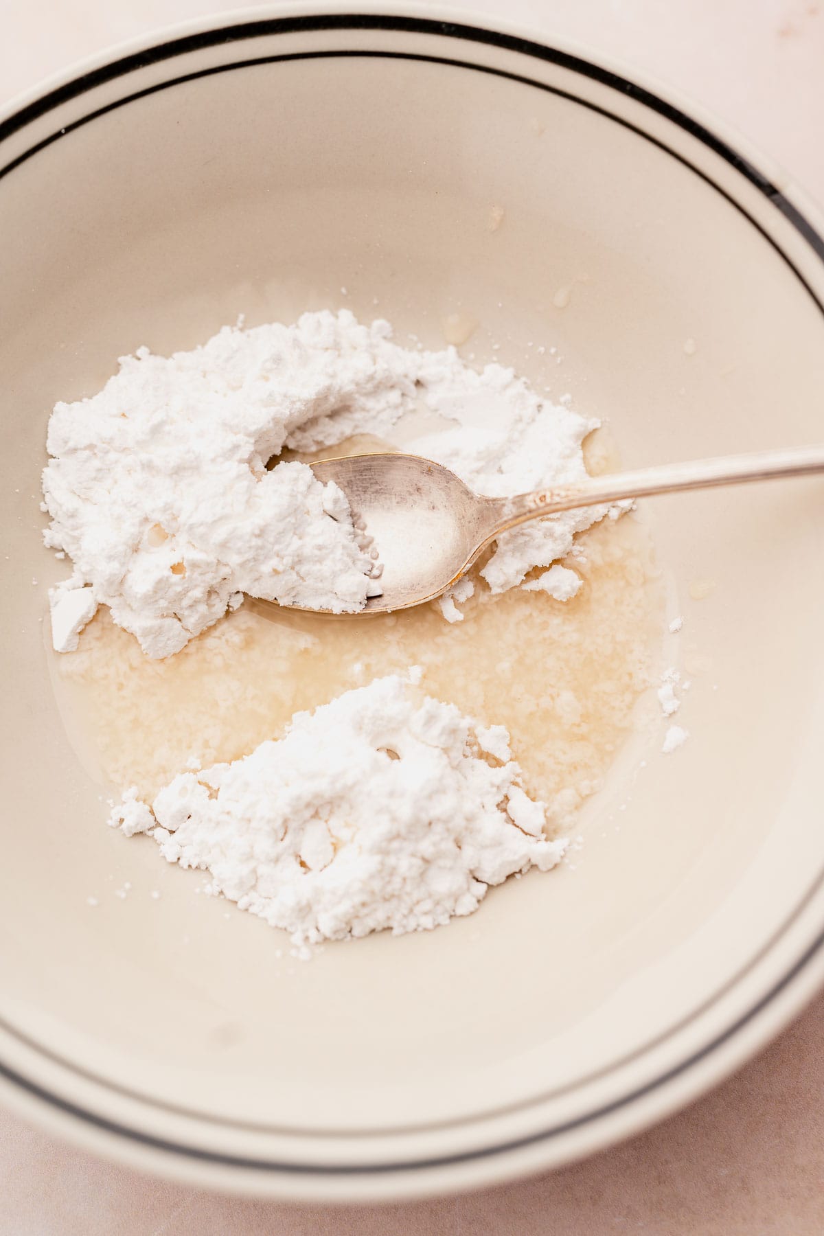 A bowl filled with a white powder, accompanied by a spoon.