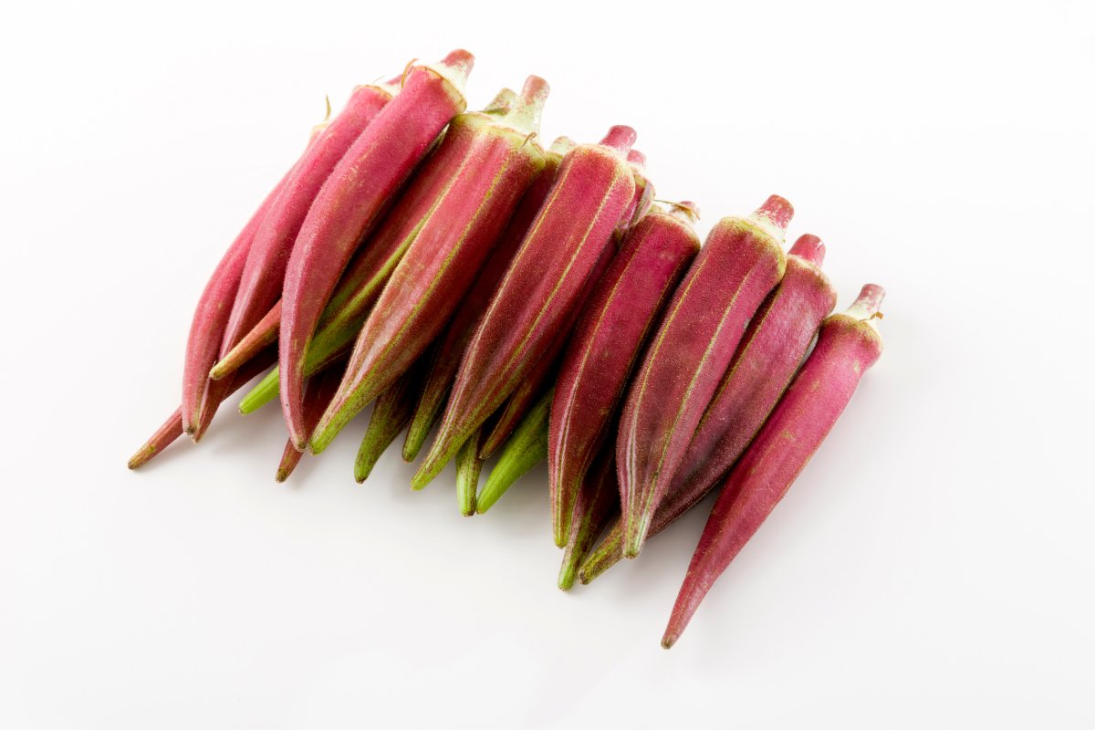 A bunch of pink okra on a white background.