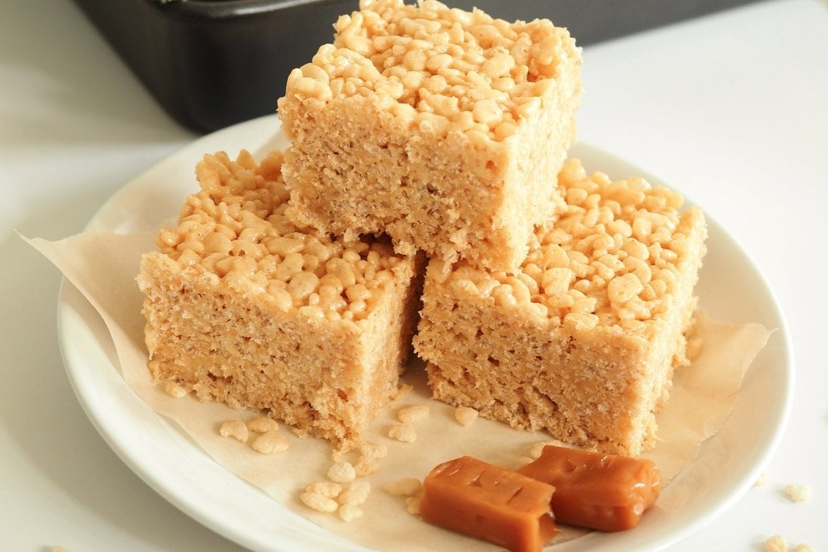 Three squares of rice krispie treats on a plate.