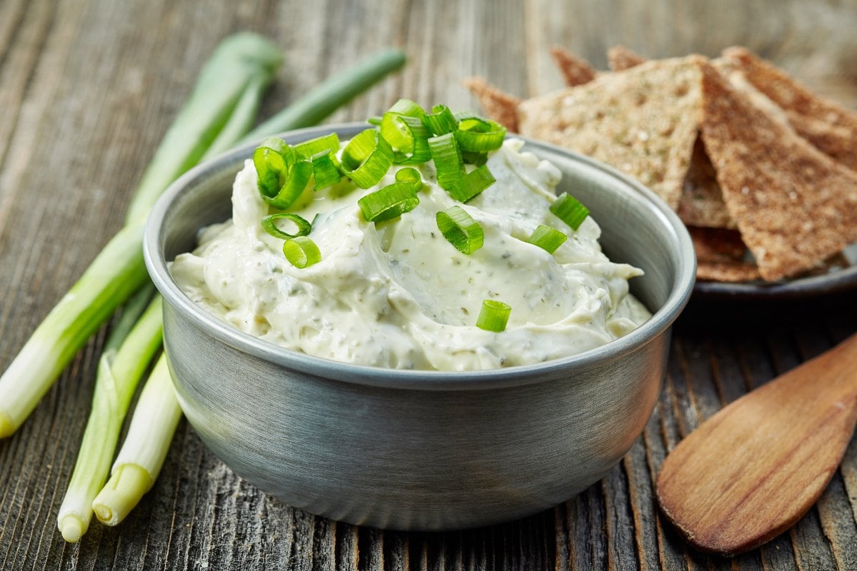 A small bowl of cream cheese sprinkled with sliced green onion.