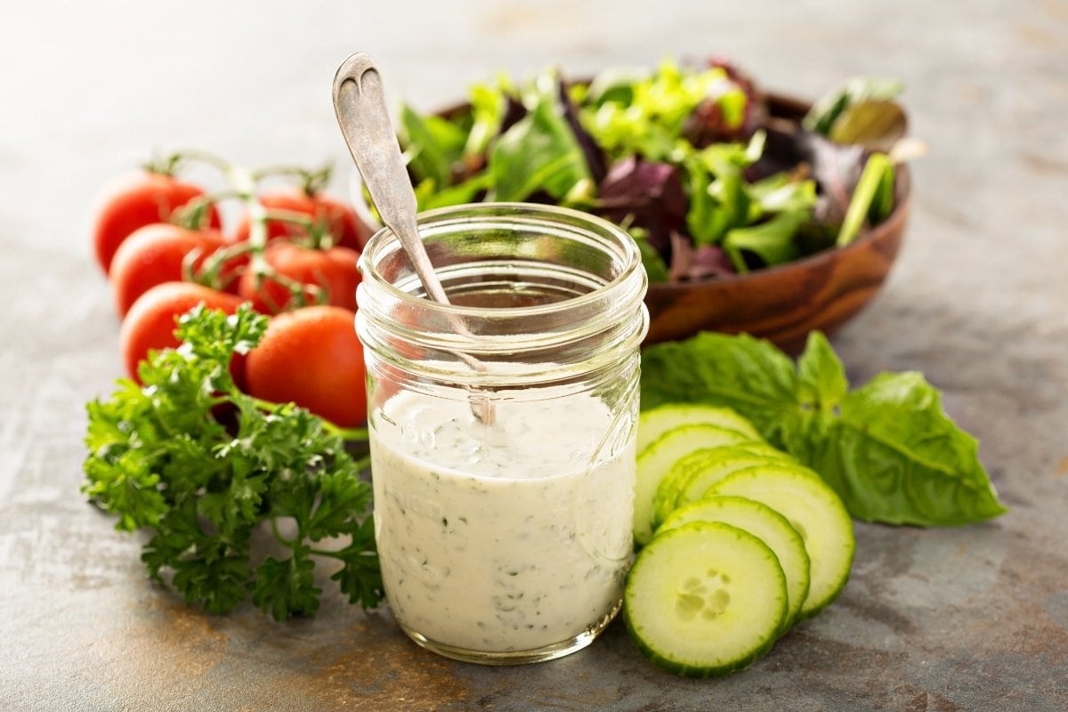 Salad dressing in a jar with cucumbers and tomatoes.