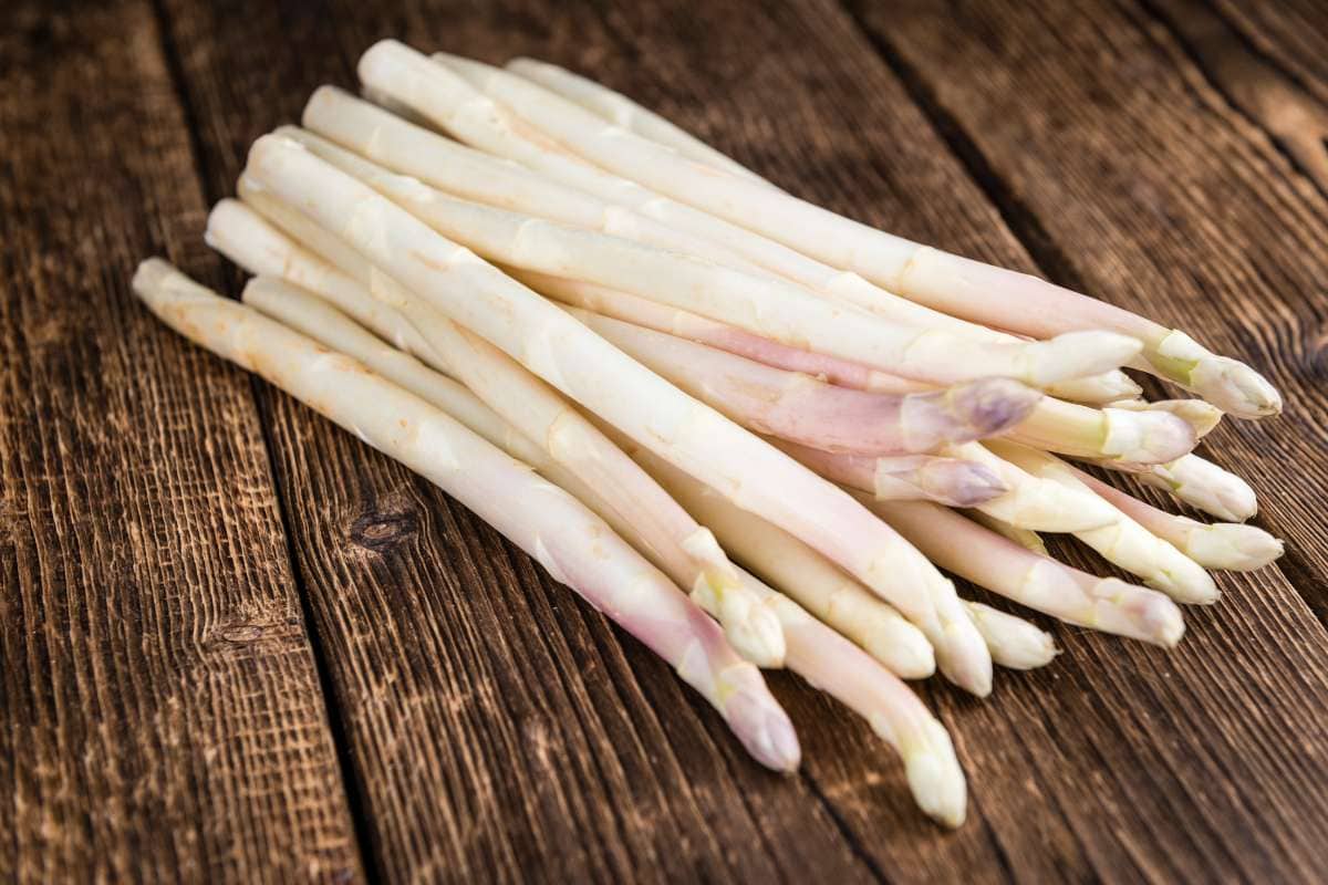 A bunch of white asparagus on a wooden table.