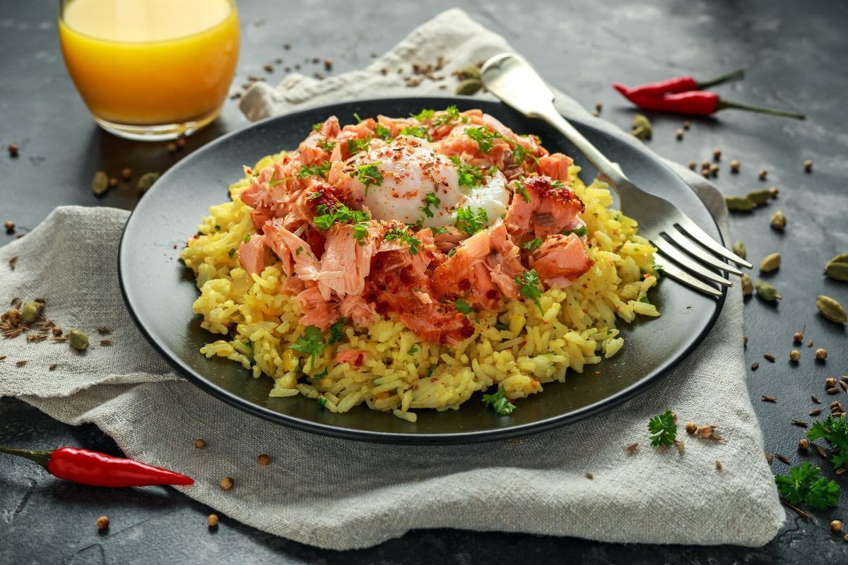 A plate of rice with salmon and eggs on it.