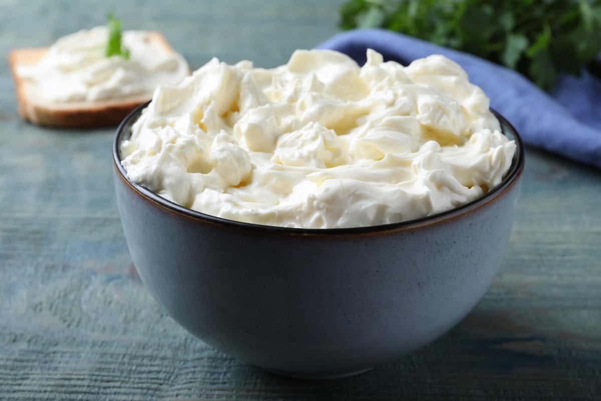 A blue ceramic bowl filled with white whipped cream cheese.