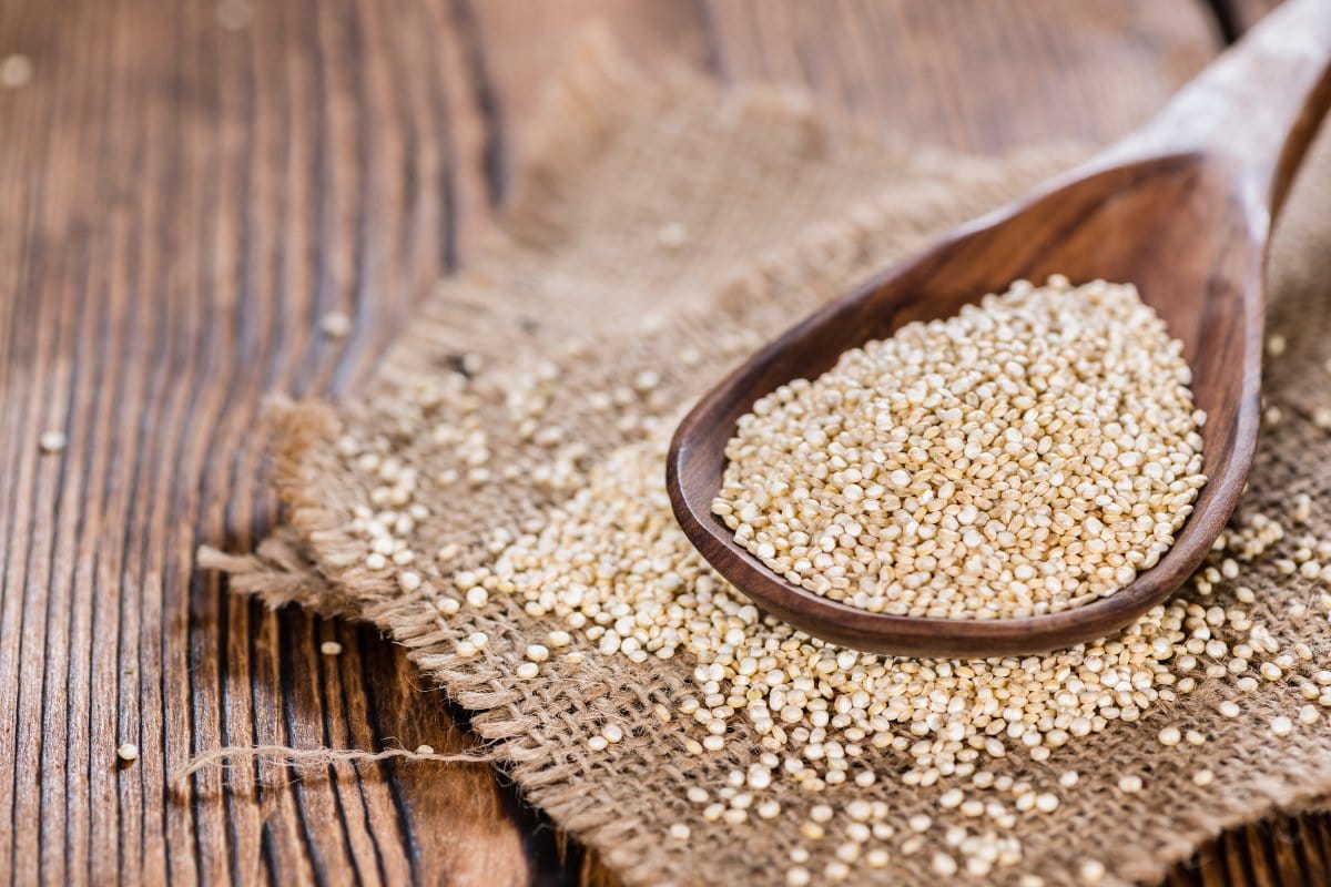 A spoon of white quinoa seeds.