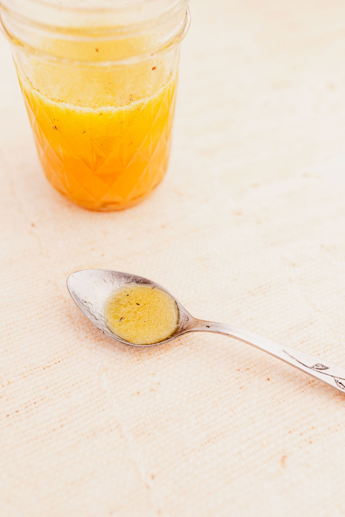 A silver spoon with a yellow dressing.