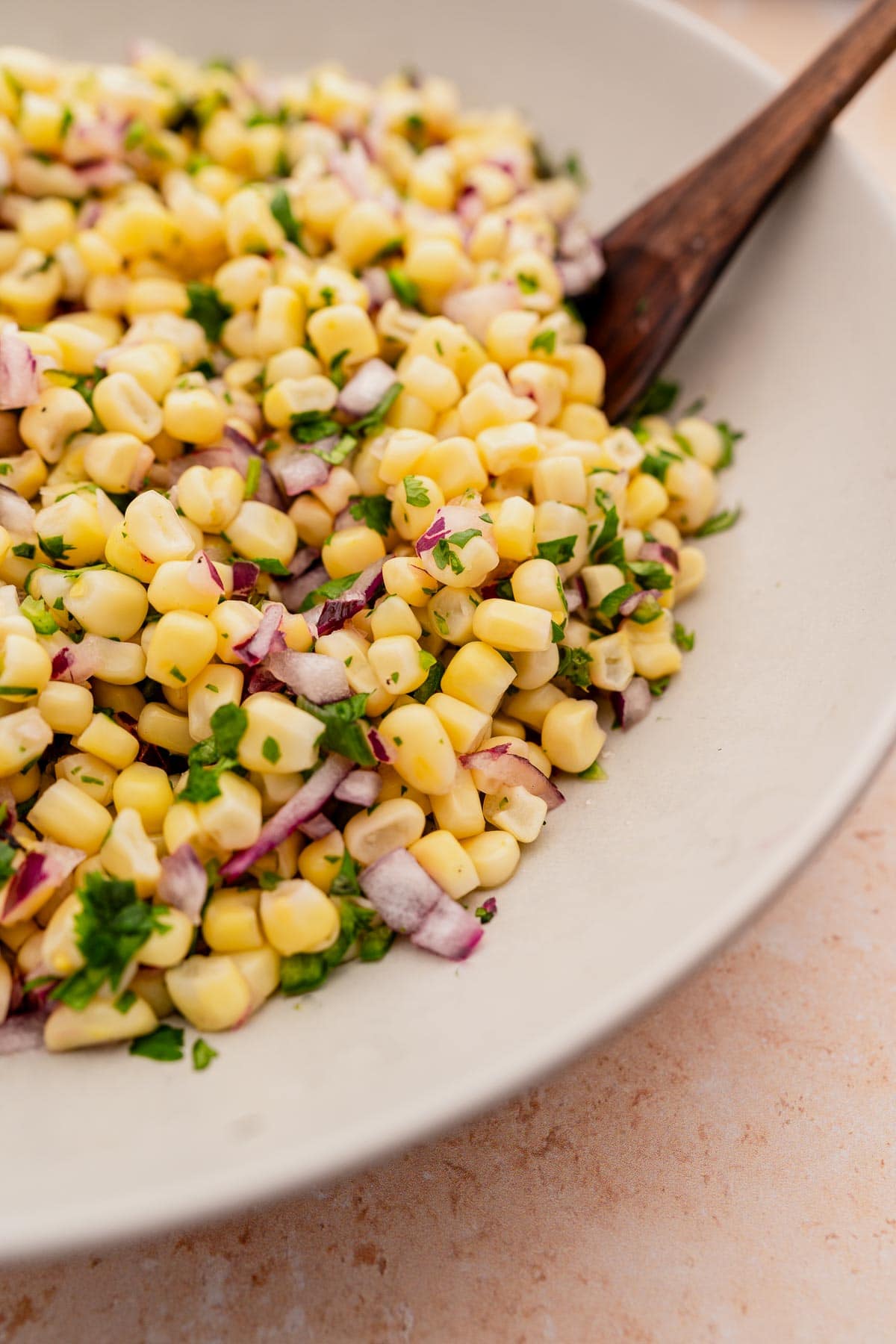 A bowl of chipotle corn salad with onions.