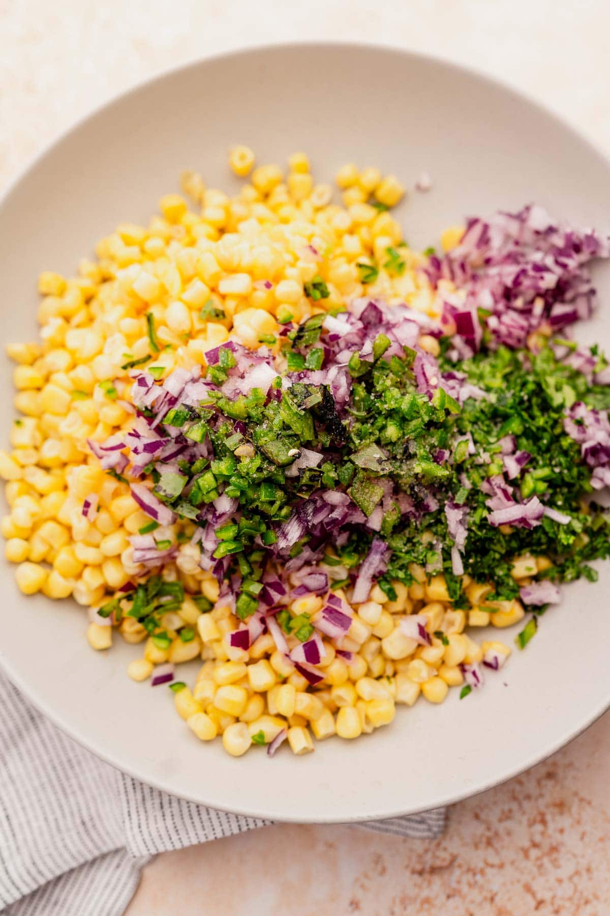 A bowl of chipotle corn salad with red cabbage and chives.