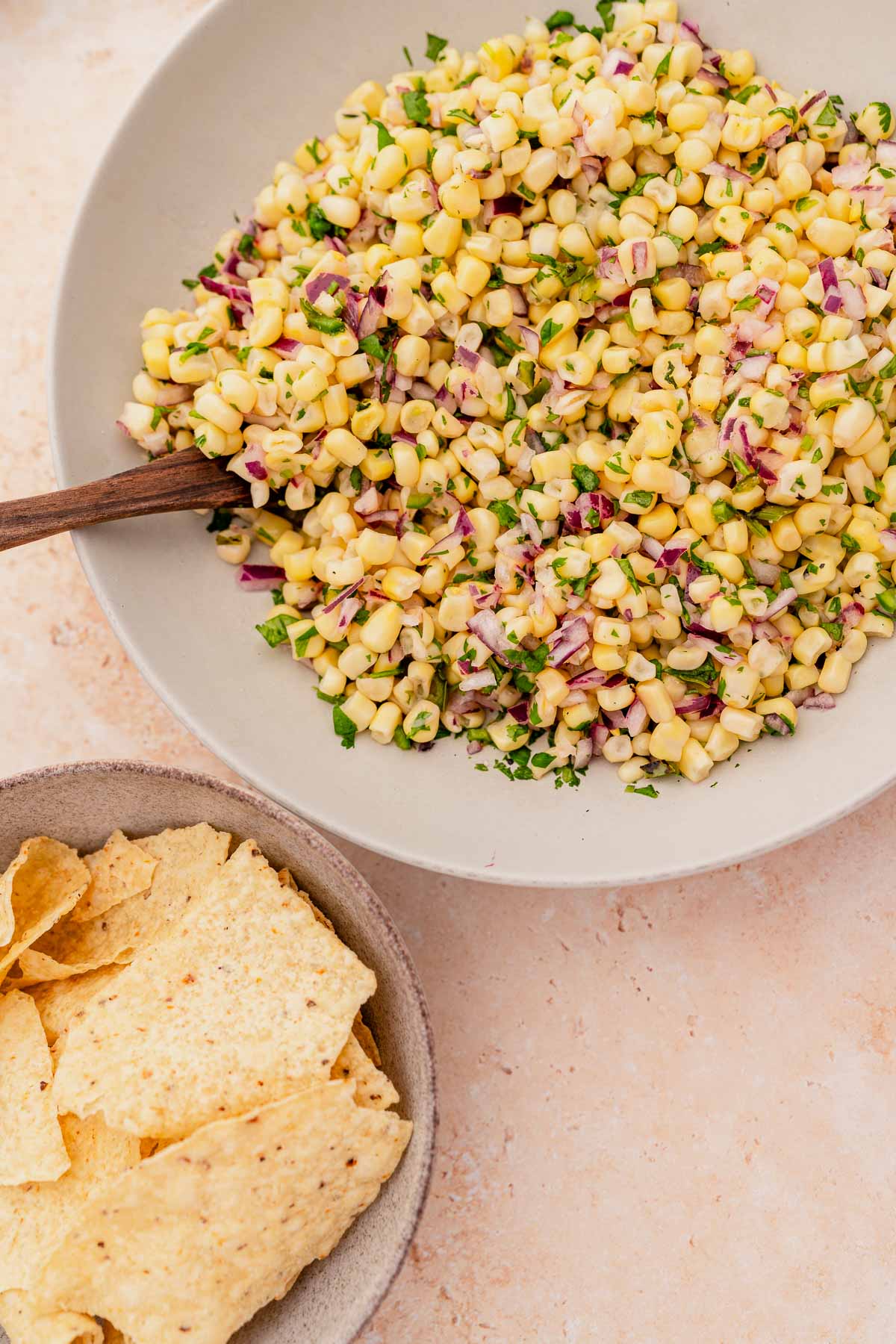 A bowl of corn salad with chipotle tortilla chips.