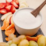 A bowl of fruit dip with a wooden spoon.