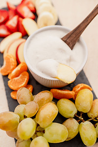 A platter of fruit and a bowl of fruit dip.