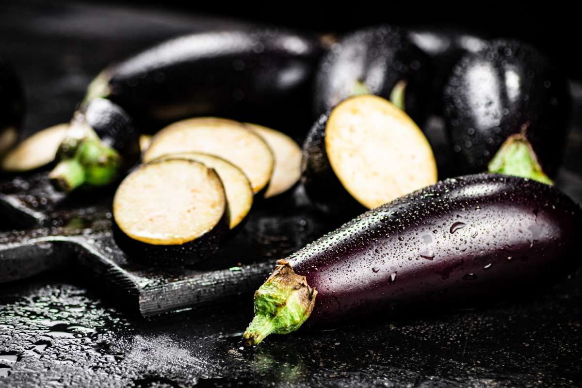 Eggplant slices on a black surface.