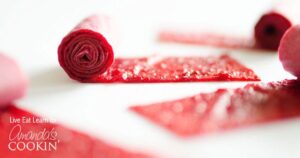 A roll of red beets on a white surface.