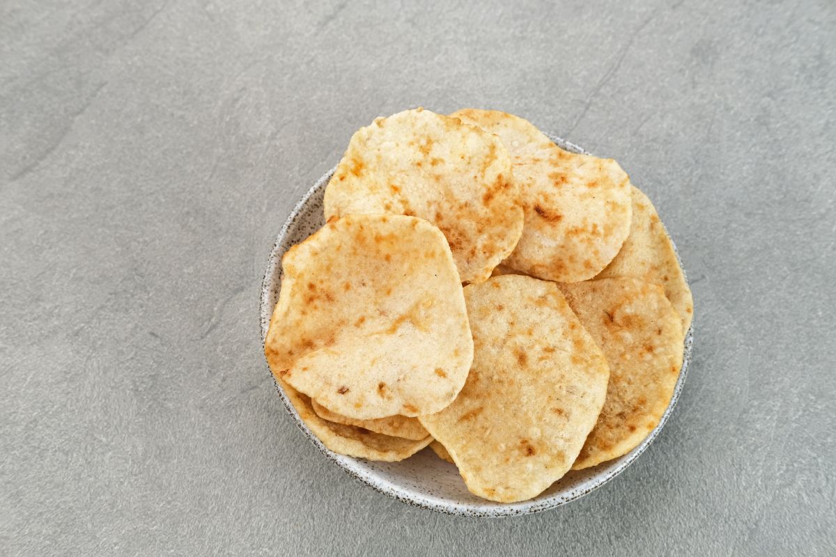 A bowl of chips on a gray table.