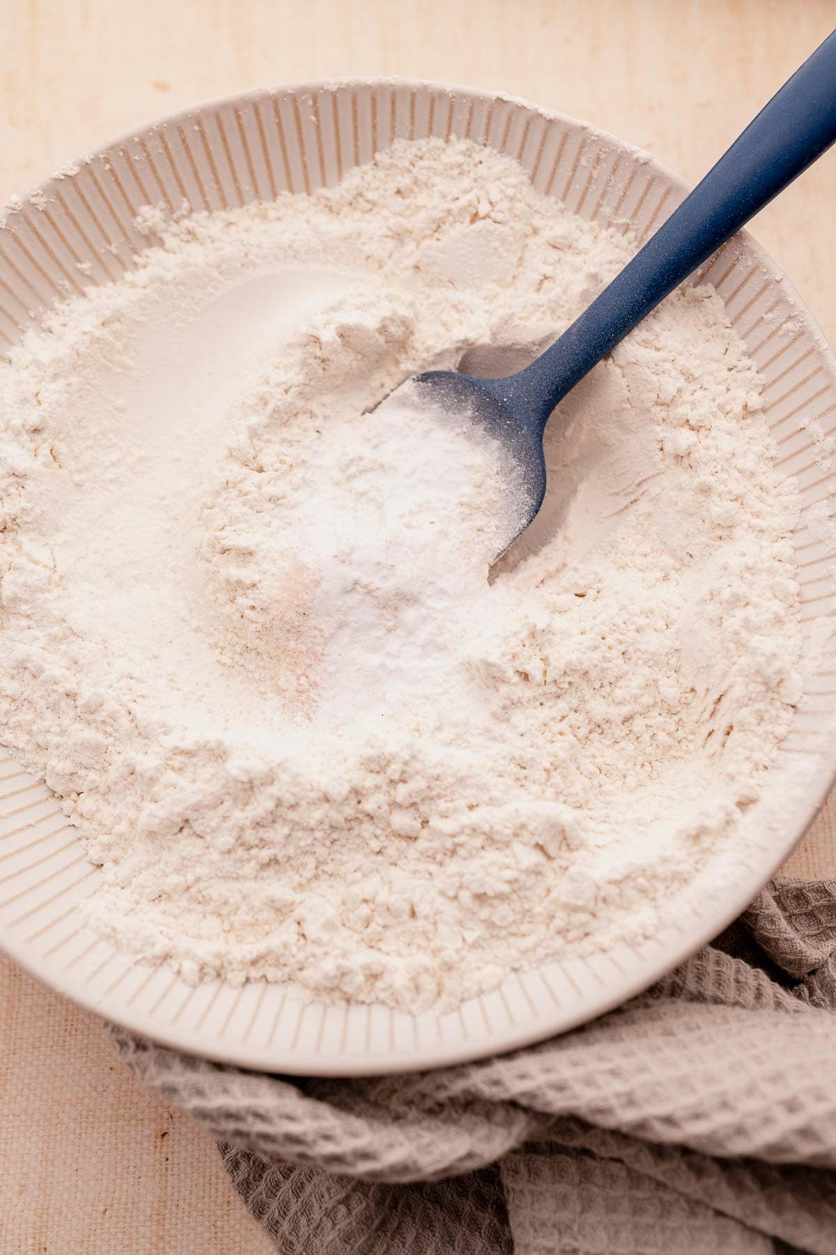 A gluten-free bowl of flour with a spoon.