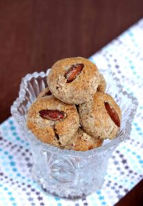 Almond cookies in a glass bowl on a napkin.