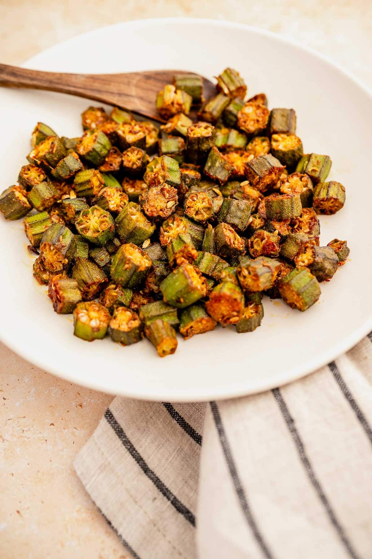 A plate of roasted okra recipe on a kitchen countertop.