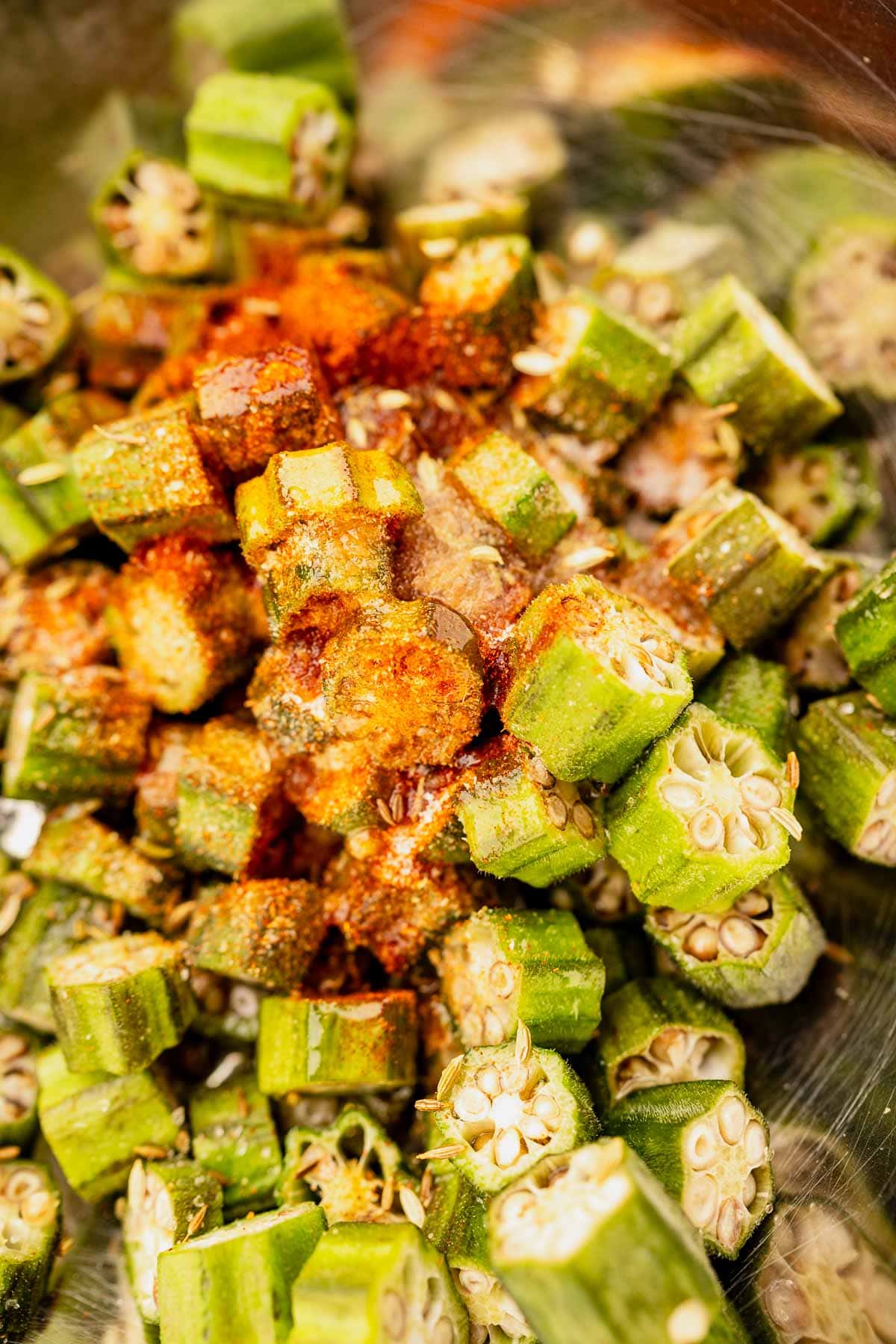 Chopped okra recipe seasoned with spices in a bowl.