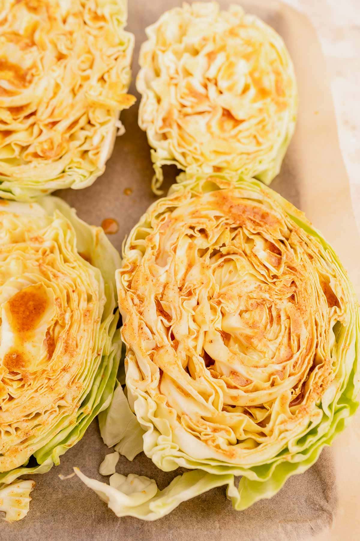Cabbage steaks on a tray, displaying layers and textures, with some outer leaves detached.