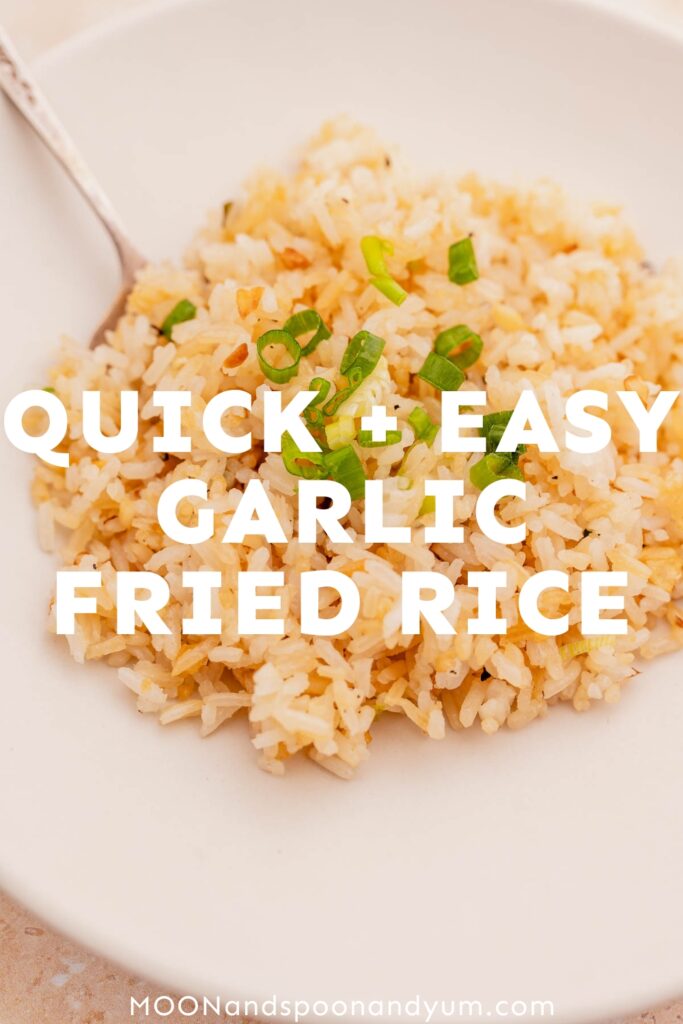 A white bowl filled with garlic fried rice, garnished with chopped green onions. Text overlay reads "Quick + Easy Garlic Fried Rice Recipe.