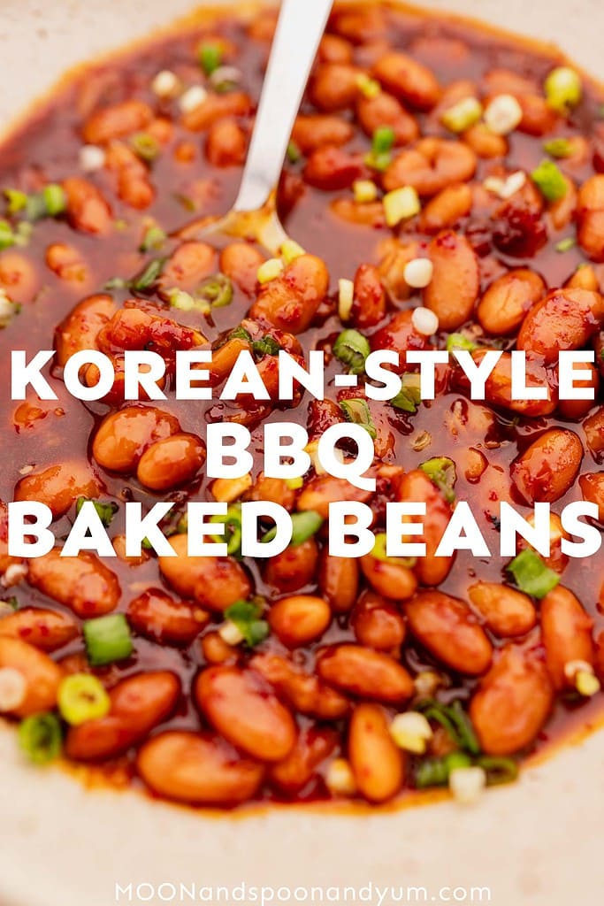 Close-up of a dish labeled "Korean-Style BBQ Baked Beans" with beans in a rich, savory Korean BBQ sauce, garnished with green onions. Text at the bottom reads "MOONandspoonandyum.com.
