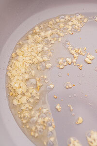 Chopped garlic sizzling in hot oil in a frying pan sets the perfect base for delicious garlic fried rice.