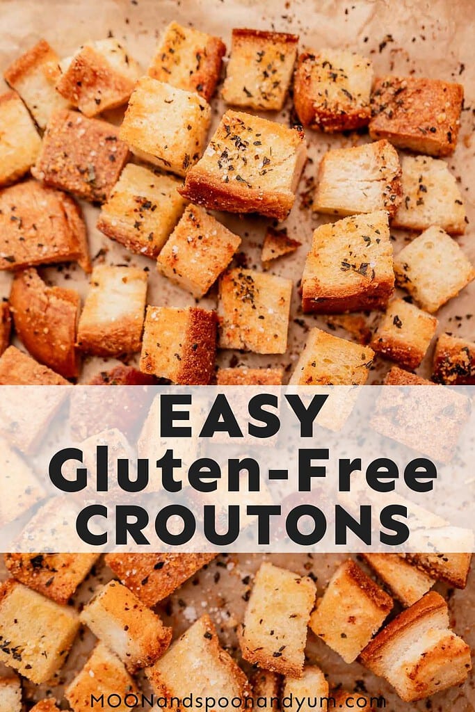 A close-up of gluten free croutons seasoned with herbs and spices, placed on parchment paper. Text overlay reads "EASY Gluten-Free CROUTONS" with a website link "MOONandspoonandyum.com".