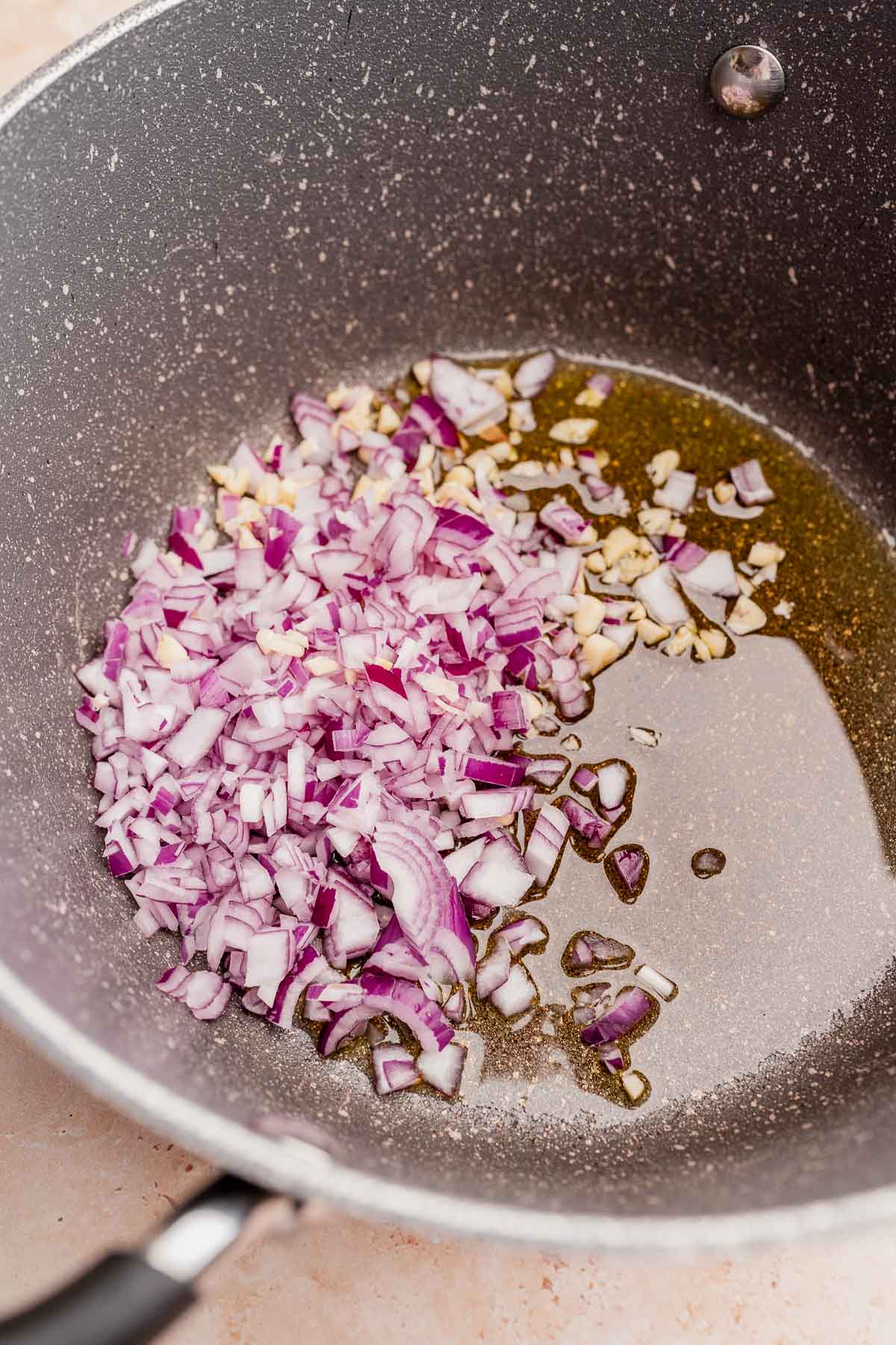 Chopped red onions in oil in a pan.