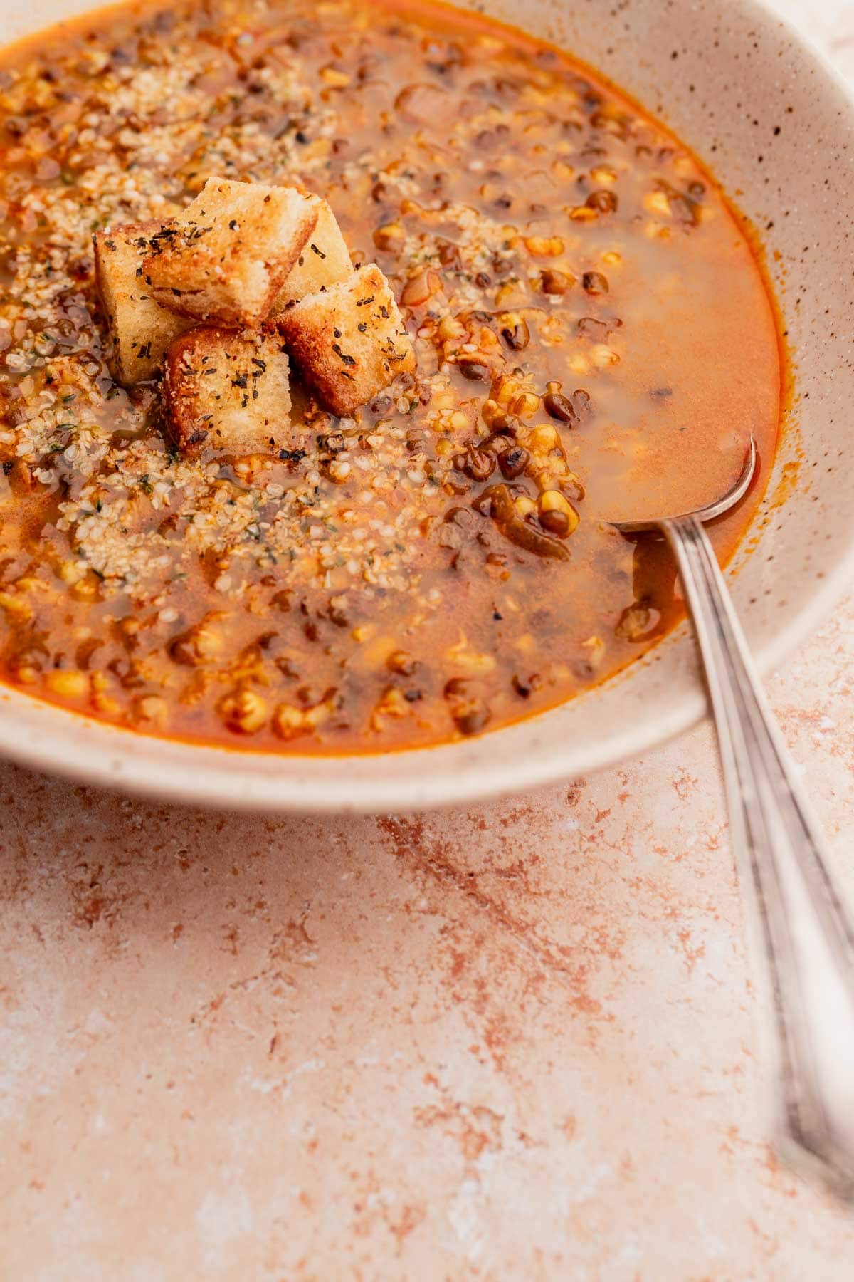 A tan speckled ceramic bowl of mung bean soup.