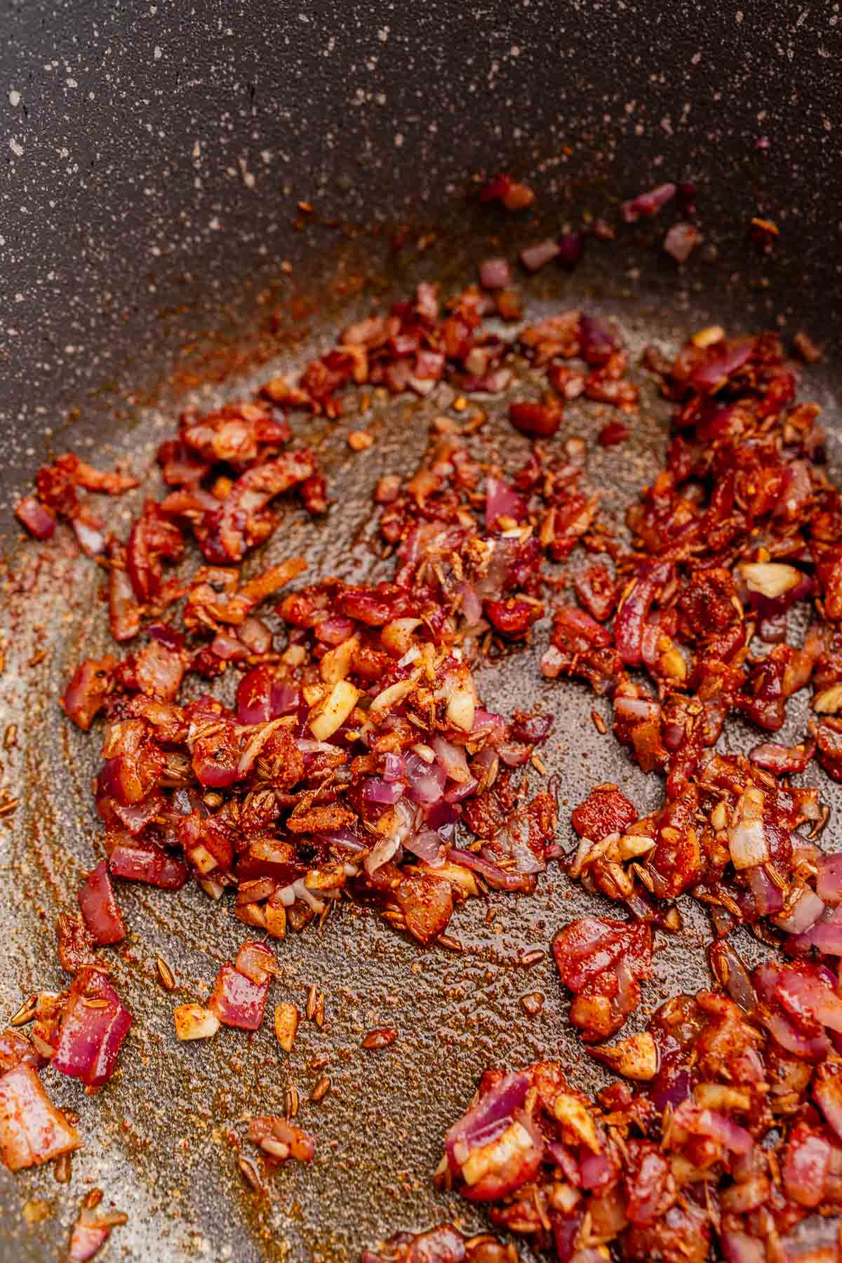Sauteed spices and onions in a pot.