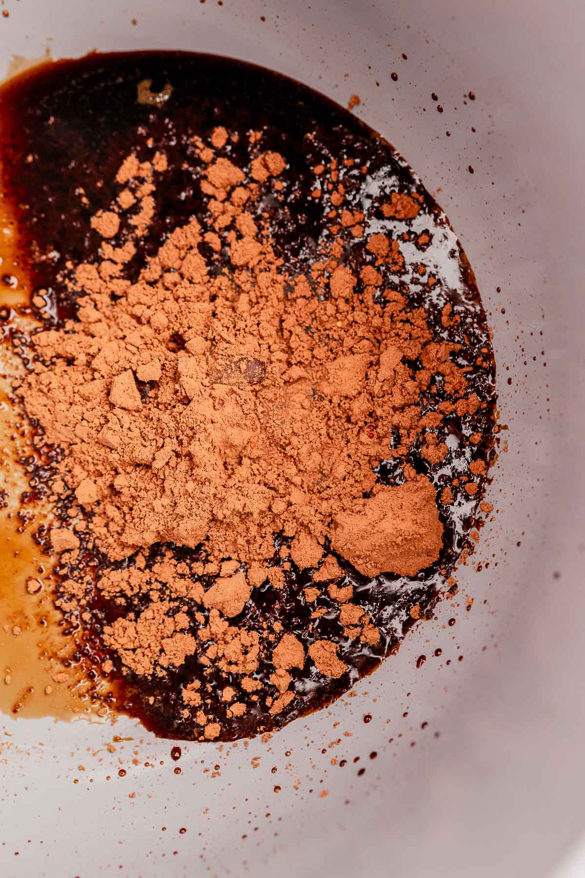 A bowl containing cocoa powder mixed with a dark liquid, hinting at the rich allure of chocolate balsamic glazed pears.