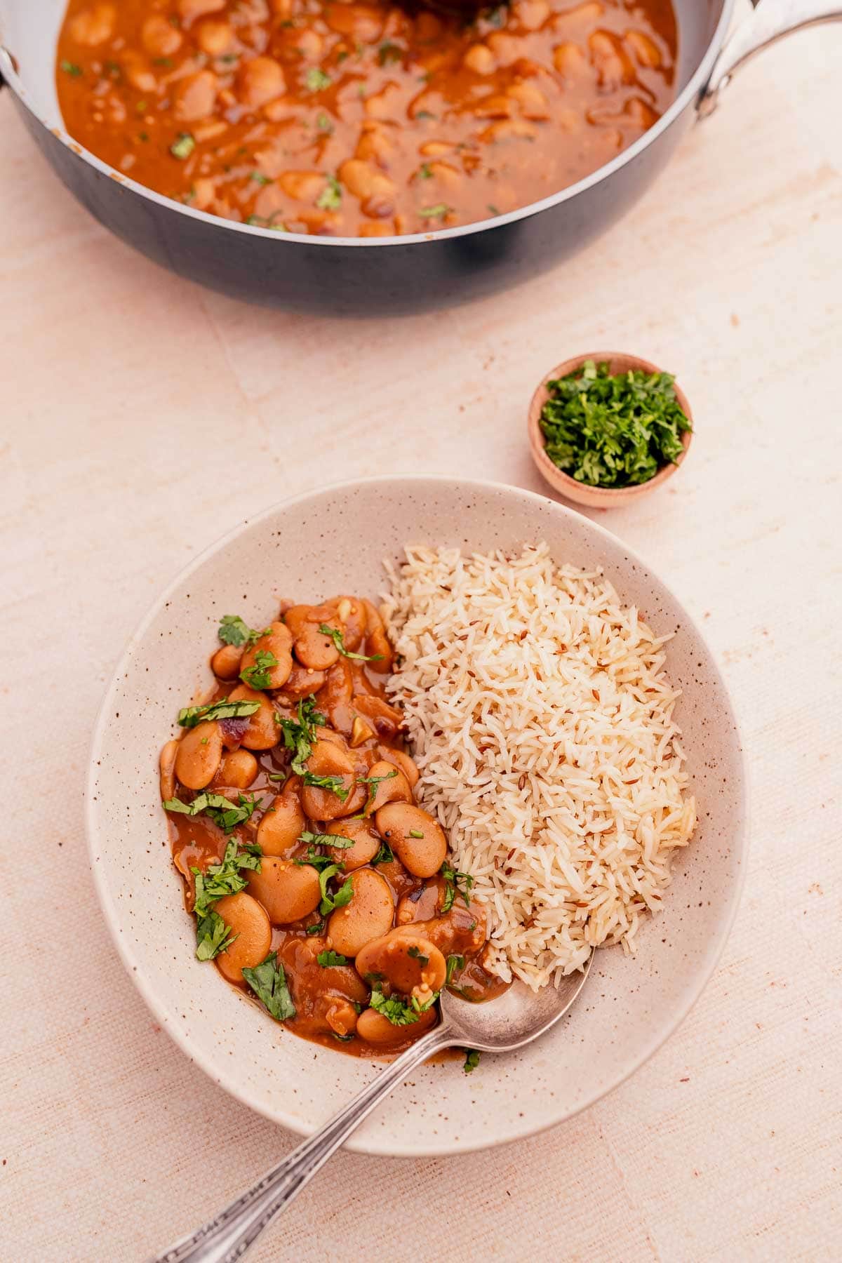 A large pot and small bowl filled with creamy butter bean curry.