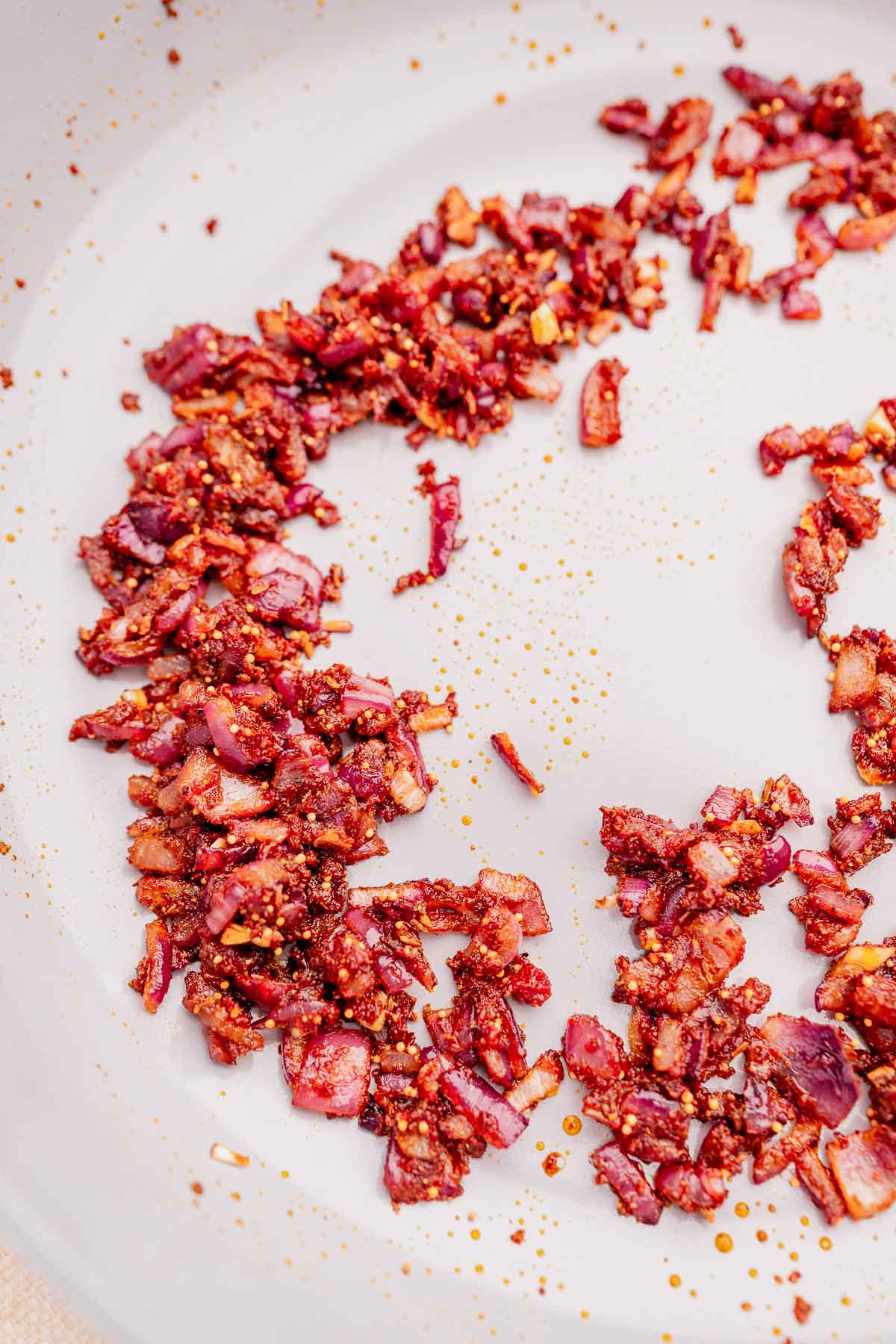 Sauteed red onions and spices in a pot.