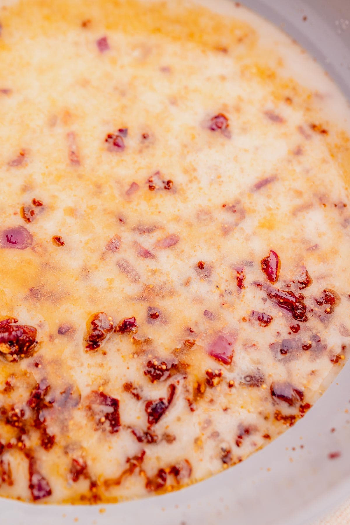 Coconut milk and onions in a pot.