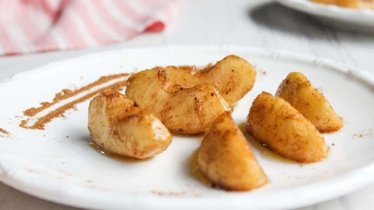 Cinnamon apple slices on a white plate.