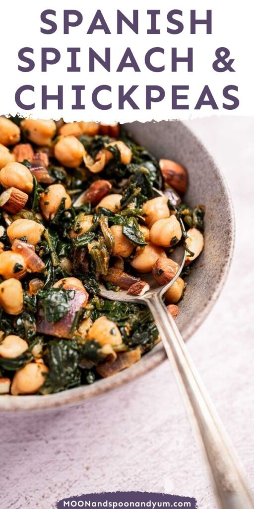 A bowl of Spanish spinach and chickpeas with almonds, featuring a serving spoon.