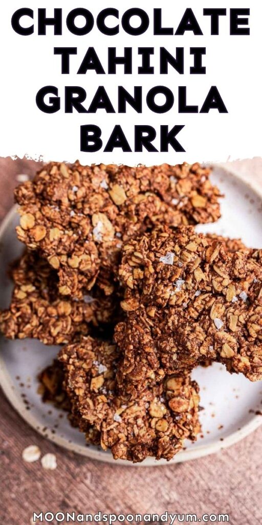 A plate of chocolate tahini granola bark on a wooden surface.