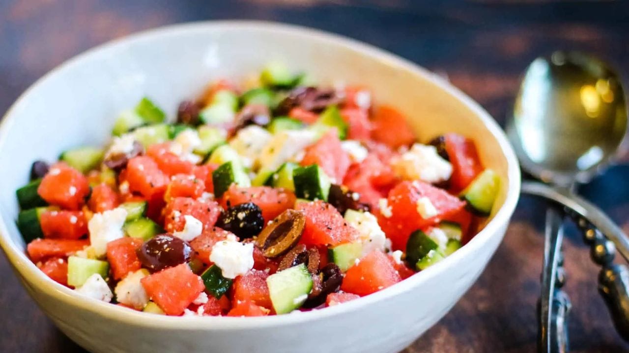 Low angle shot of a bowl of watermelon salad with kalamata olives and feta cheese.